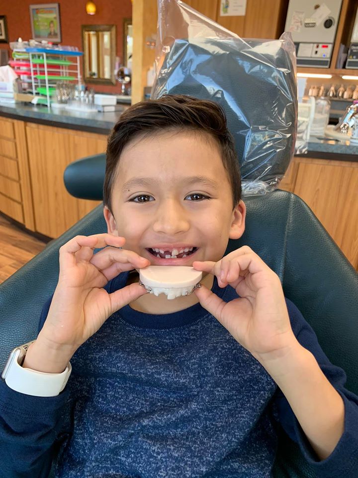 patient at kidzdent holding a retainer